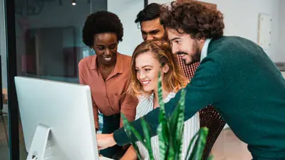 Shot of a group of colleagues using computer together at work.