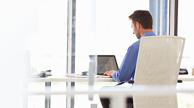 Download Savings Calculator A man working on his laptop