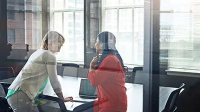 Two businesswomen working together in a conference room
